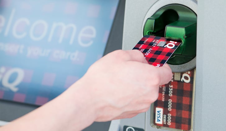 Hand inserting credit card at gas station pump. 