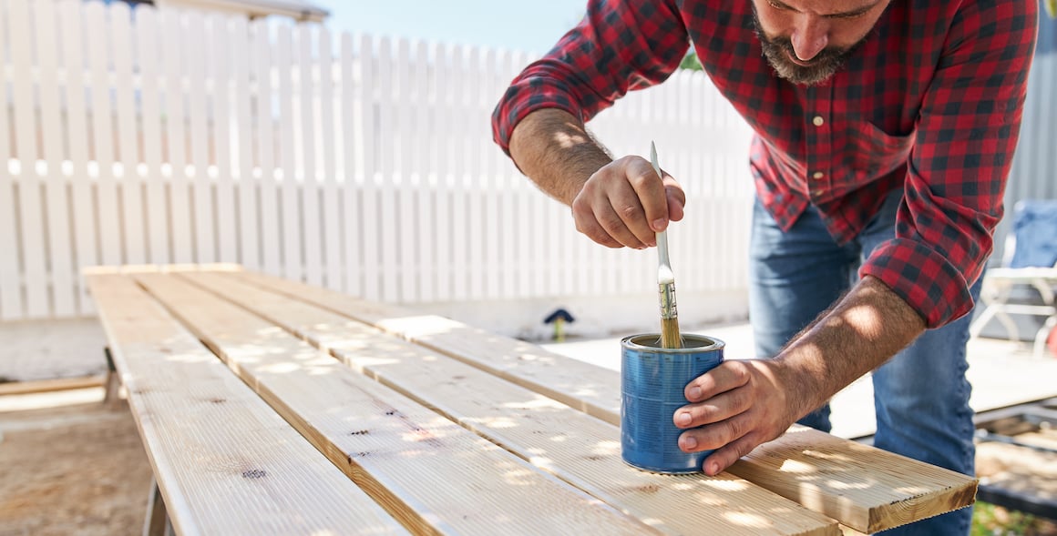 iQ member painting wooden boards for home repair