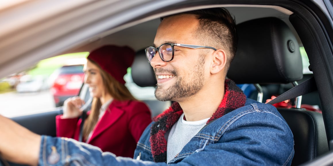 iQ members in car with man driving and woman smiling in passenger seat