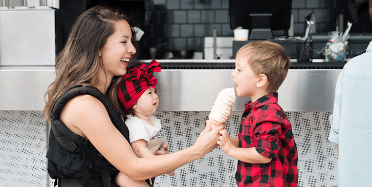 Mother sharing ice cream with her two children