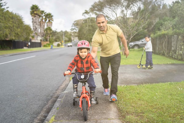 man pushing his son on tricycle